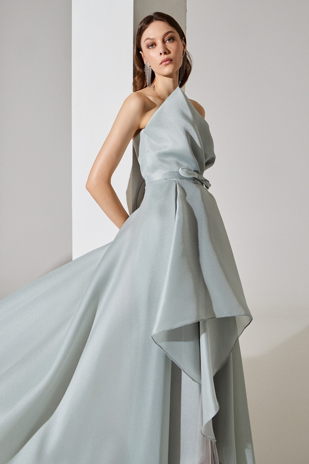 Asymmetrical strapless evening dress made of organza with a belt at the waist