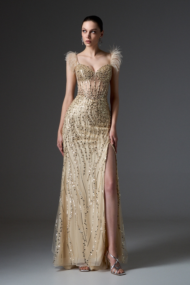 Evening long fully embroidered dress with boned top, feathers on the shoulders, and a slit