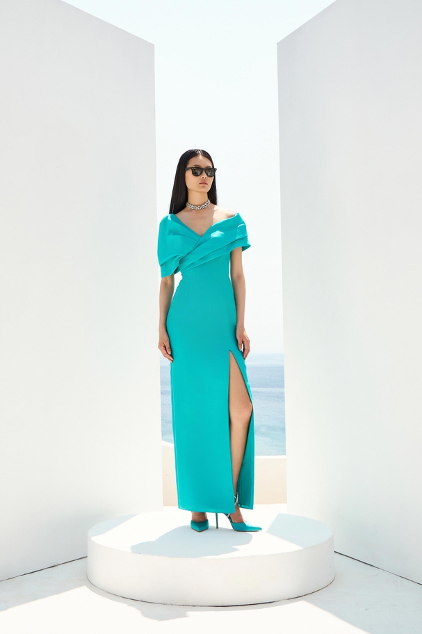 Βραδινό εφαρμοστό φόρεμα με γιακά που καλύπτει τους ώμους και σκίσιμο.