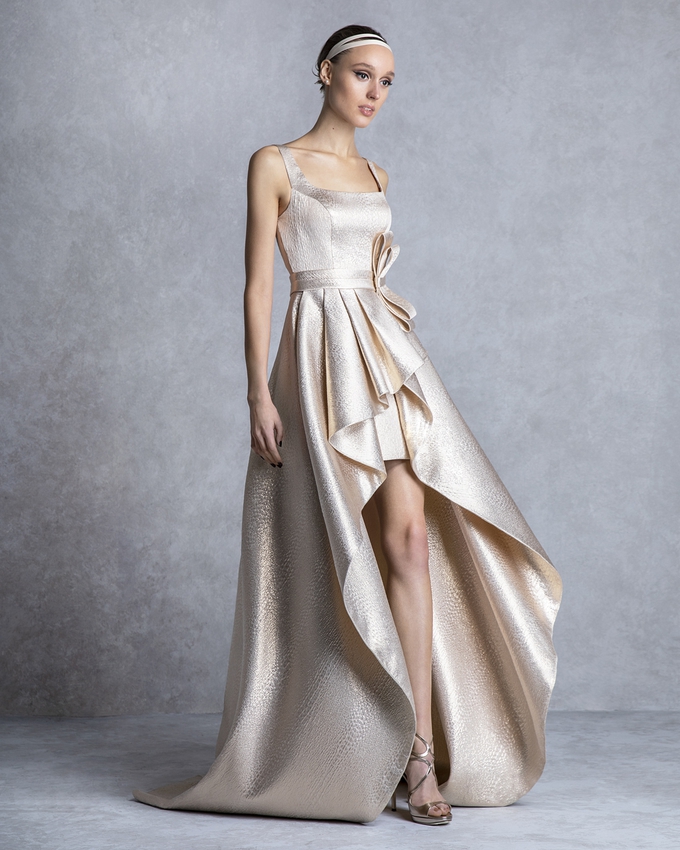 Long asymmetrical evening dress with a bow and shining brocade