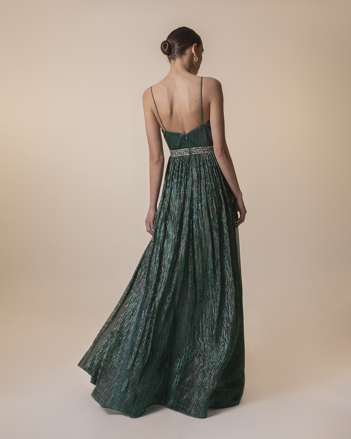 Long pleated evening dress with shining fabric and beading around the waist